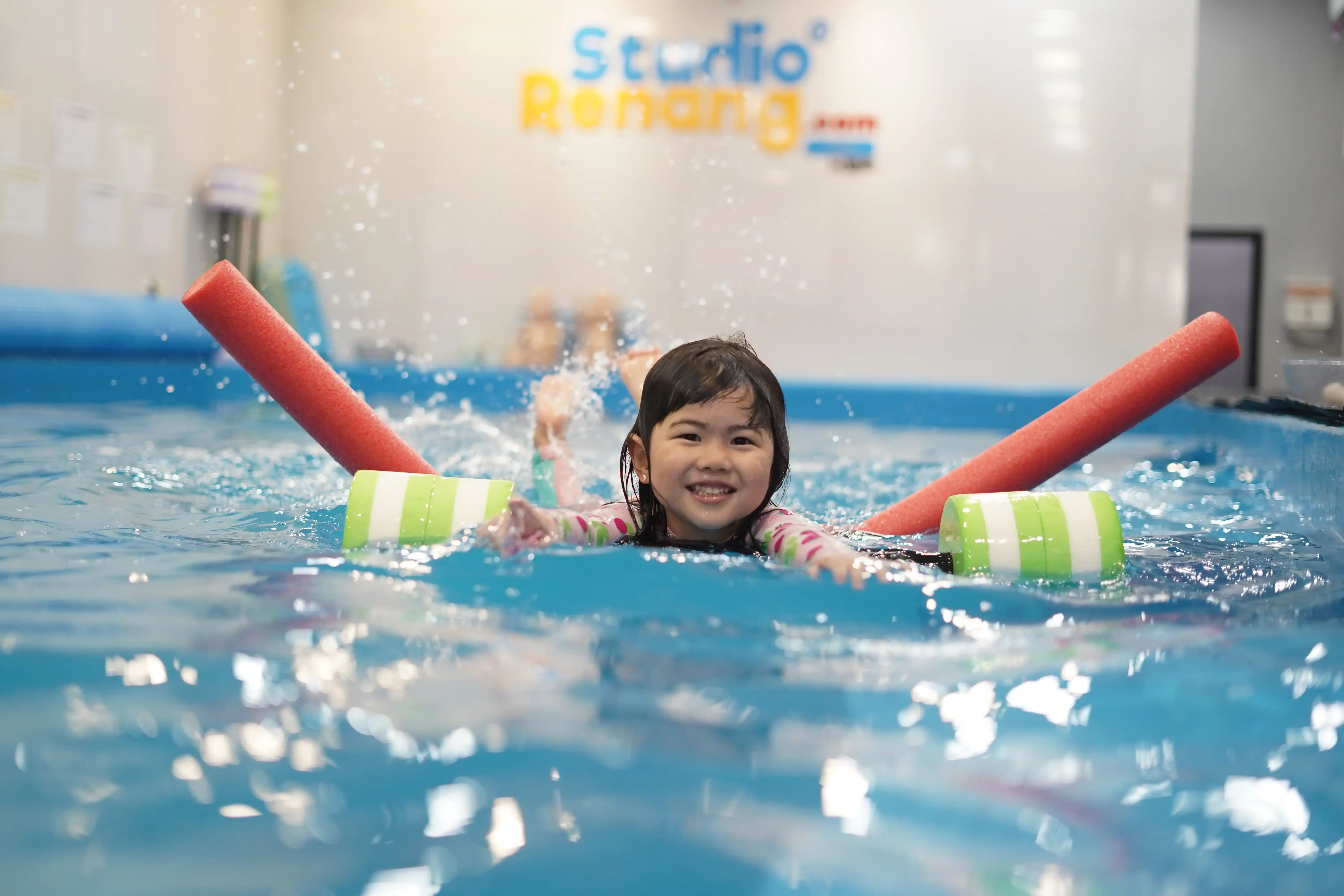 Instruktur mengajari bayi berenang di kolam khusus anak